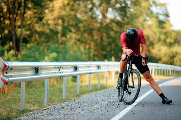 ciclista-agotado-parado-en-la-carretera